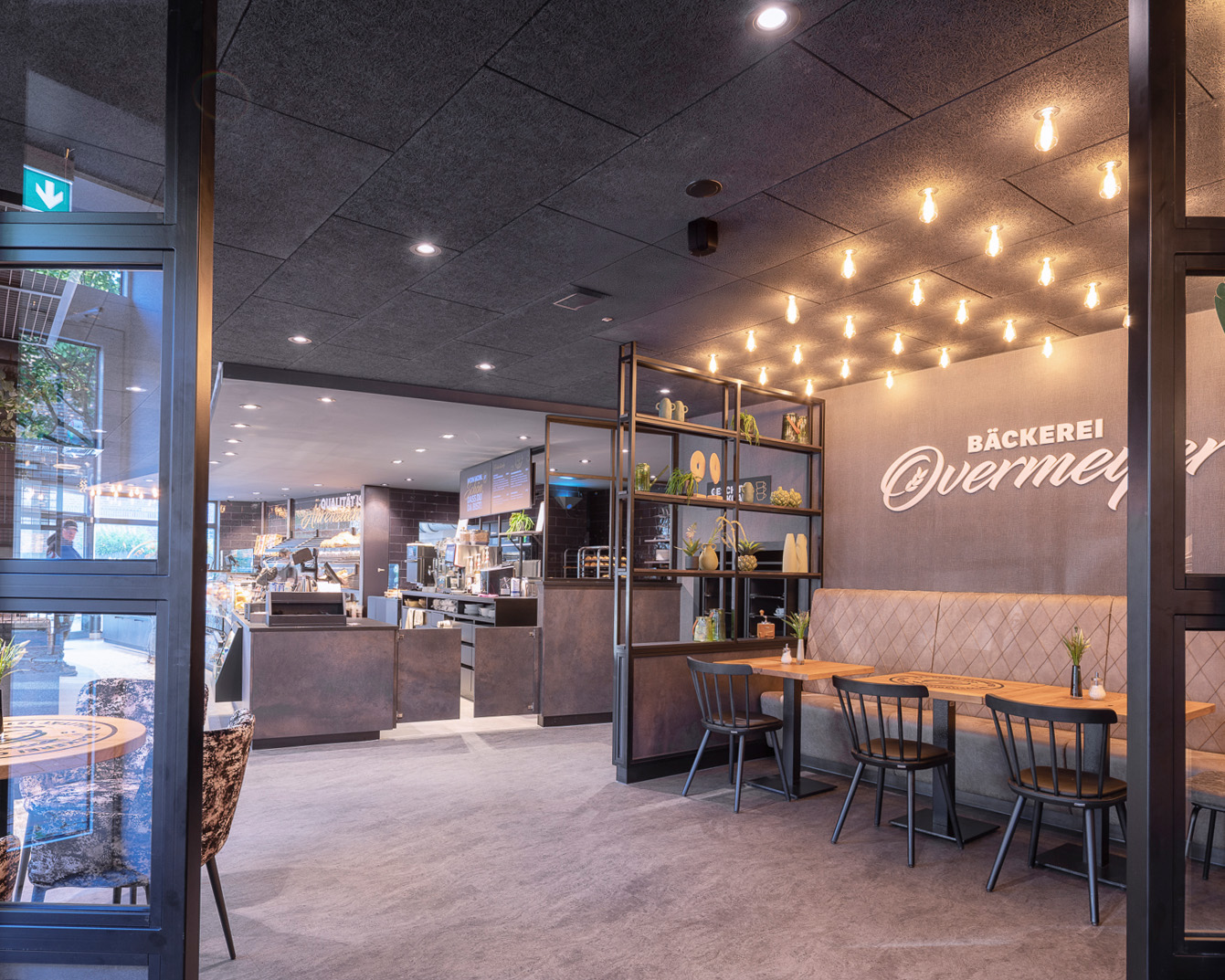 Innenansicht der modern gestalteten Bäckerei Overmeyer in Steinfeld mit Cafébereich und Brottheke